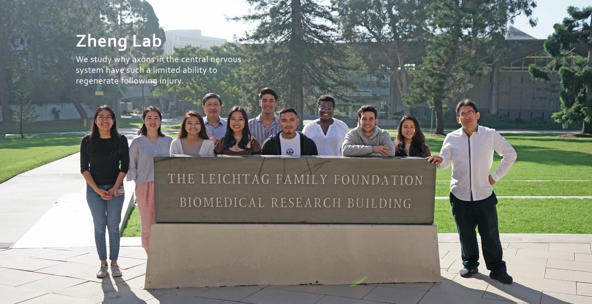 zheng lab members standing outside in front of the leichtag biomedical research building sign